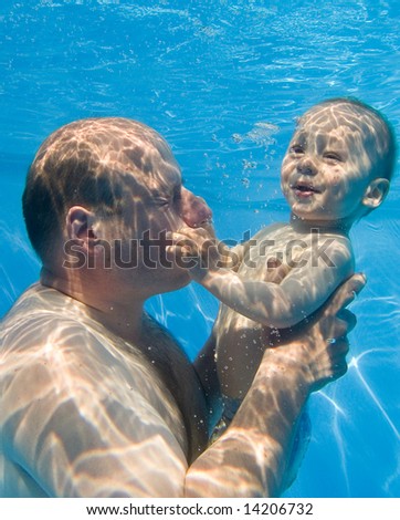 Father and happy son in the pool