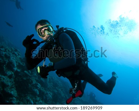 Scuba diver makes OK sign underwater