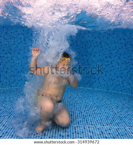 Young Boy jumps in the Swimming Pool. Summer Vacation Fun