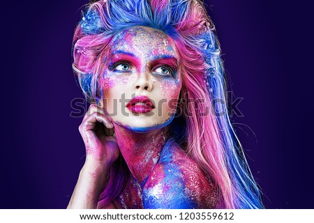 close up  portrait of young beautiful girl with colorful face painting. Halloween professional makeup. hair in paint. beauty portrait. blue and pink hair