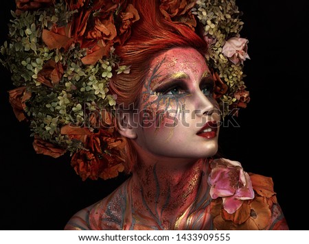 close up portrait of young beautiful girl with flower professional makeup. elf princess with flower crown on head.  Halloween makeup. bright face art. spring fairy of flowers. orange hair
