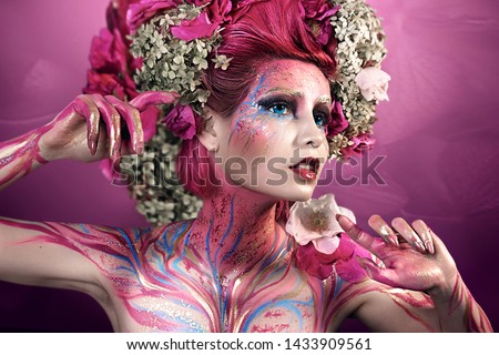 close up portrait of young beautiful girl with flower professional makeup. elf princess with flower crown on head.  Halloween makeup. bright face art. spring fairy of flowers. pink hair
