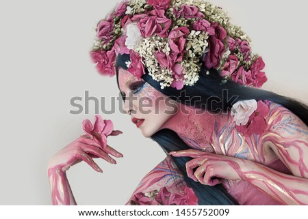 close up portrait of young beautiful girl with flower professional makeup. elf princess with flower crown on head.  Halloween makeup. bright face art. spring fairy of flowers. black lush hairdo
