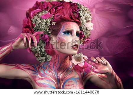 close up portrait of young beautiful girl with flower professional makeup. elf princess with flower crown on head.  Halloween makeup. bright face art. spring fairy of flowers. pink hair
