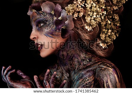 close up portrait of young beautiful girl with Halloween professional makeup. elf princess with flower crown on head. bright face art. spring fairy of flowers