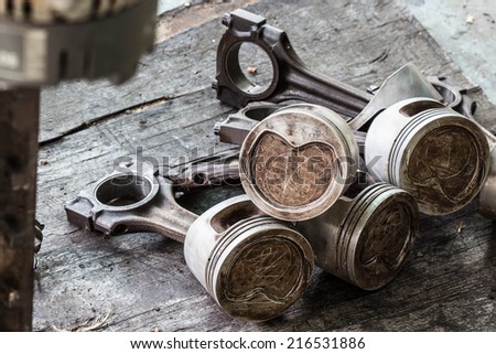 Worn out piston and connecting rod, dismantled from the internal combustion engine on wood background