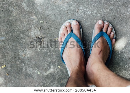 Male foot in flip-flop on street