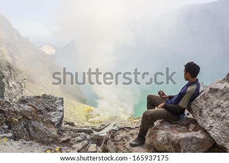 CIRCA JUNE 2012 - JAVA, INDONESIA - Sulfur mine worker resting at the Ijen volcano crater, on 24 June 2012, in Java, Indonesia.
