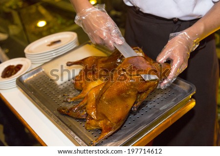 18 MAY 2014 - BEIJING, CHINA - A chef slices Beijing Duck at a restaurant in Beijing