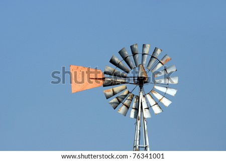 Green energy a farm windmill used to pump water for cattle a resource to draw water from an under ground water source.