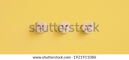 Wooden blocks with the happy face smile face symbol on yellow background, evaluation, Increase rating, Customer experience, satisfaction and best excellent services rating concept