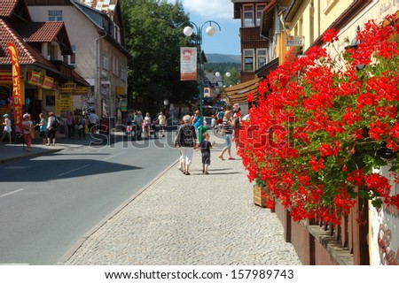 KARPACZ, POLAND - AUGUST 14,2013: Unidentified people and flowers on main street in Karpacz city in Karkonosze mountains Poland