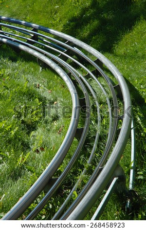 Roller coaster tracks turn above green grass.