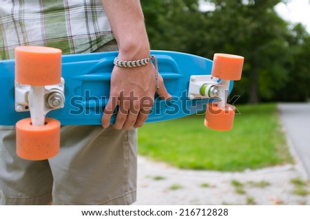 man in shirt holding skate board