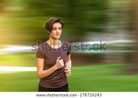 A girl running by park in the morning light, training for marathon, healthy lifestyle