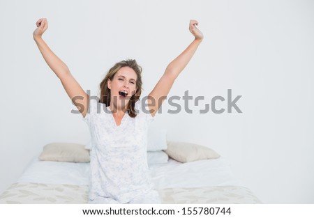 Pretty woman in bed stretching when waking up