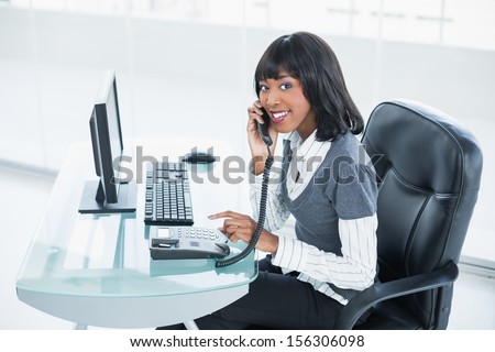 Smiling classy businesswoman answering the phone in bright office