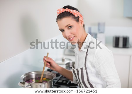 Happy gorgeous cook posing in bright kitchen