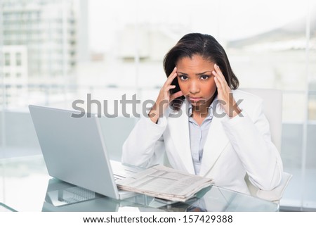 Puzzled young dark haired businesswoman trying to understand a document in bright office
