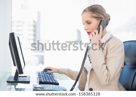 Peaceful blonde businesswoman answering the phone in bright office