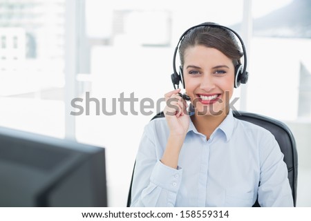 Beautiful classy brown haired operator answering a call in bright office