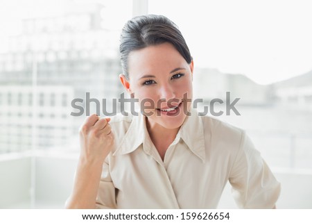 Close-up portrait of an elegant and happy businesswoman in a bright office