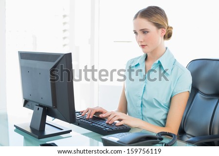 Classy calm businesswoman working at computer in bright office