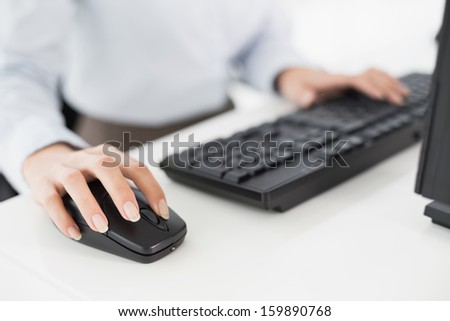 Close-up of hands computer keyboard and mouse in an office