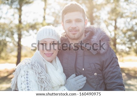 Portrait of a smiling young couple in winter clothing in the woods