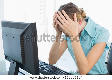 Classy frustrated businesswoman working at computer in bright office