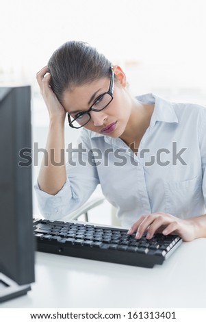 Portrait of a young businesswoman sitting in front of computer at a bright office