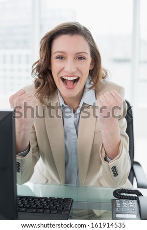 Portrait of an elegant businesswoman cheering with clenched fists in office