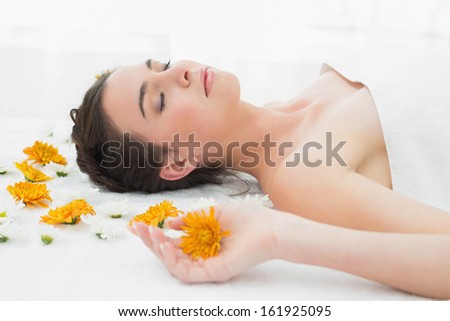 Close up of a beautiful young woman with flowers in beauty salon
