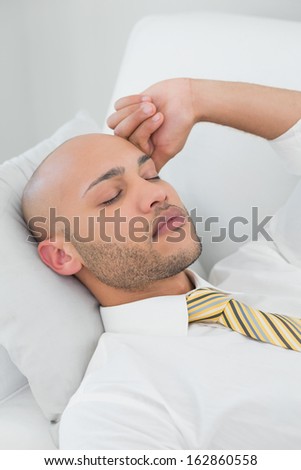 Close up of a handsome young businessman sleeping on sofa at home