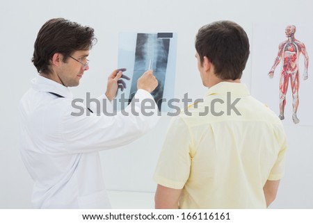 Male doctor explaining spine x-ray to patient in the medical office