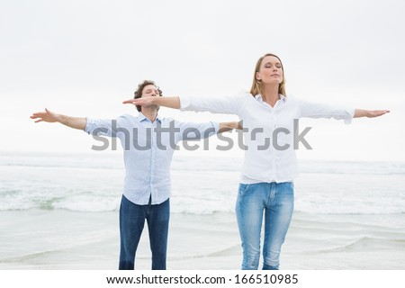 Peaceful casual young woman and man with eyes closed at the beach