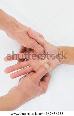 Extreme close-up of a doctor examining a female patient\'s palm in the medical office