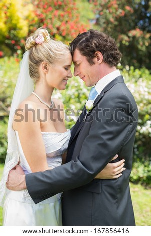 Pretty wife hugging her new husband in the countryside