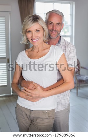 Portrait of a mature man embracing woman from behind at home