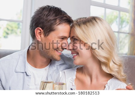 Close-up of a loving young couple with champagne flutes at home
