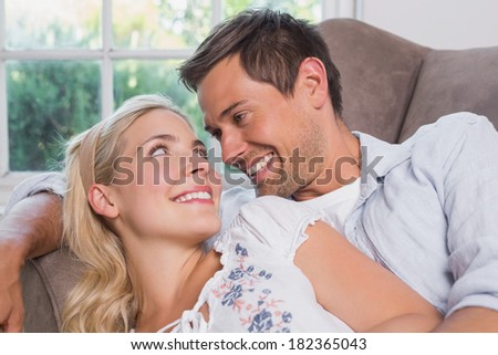 Cheerful casual young couple in living room at home