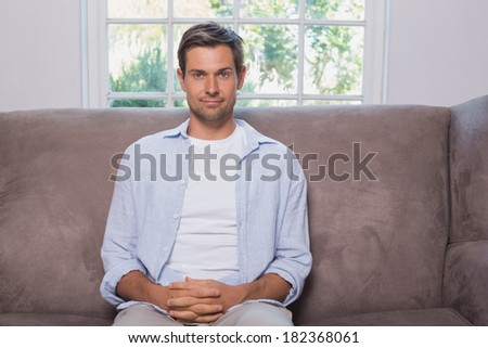 Portrait of a casual young man sitting on sofa at home