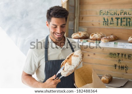 Portrait of confident male cafe owner with sweet food at coffee shop