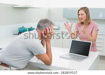 Unhappy couple having an argument in the kitchen at home