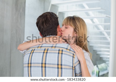 Close-up of a loving young woman kissing man at home