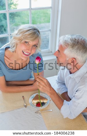 High angle portrait of a mature man giving flower to a happy woman