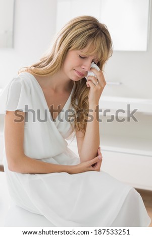 Sad young woman crying in the bathroom at home