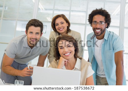 Group of happy business people using laptop together at office desk