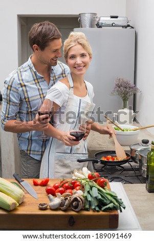 Portrait of a loving young couple with wine glasses in the kitchen at home