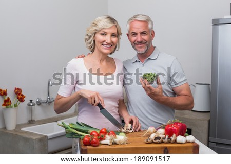 Portrait of a happy mature couple preparing food together in the kitchen at home